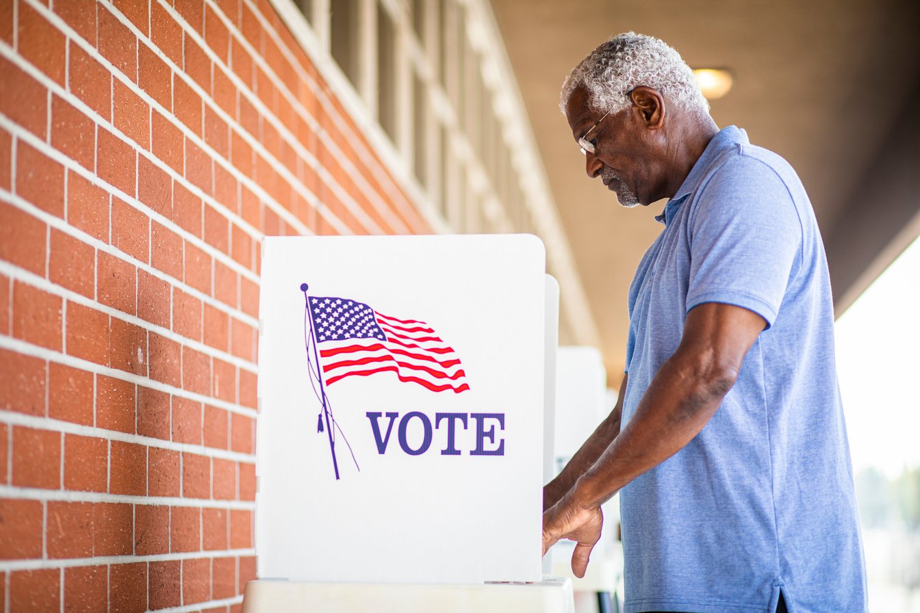 Senior Black Man Voting at Booth